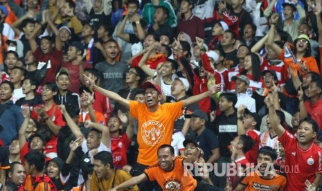 Suporter Persija Jakarta, Jakmania, bersorak saat mengetahui tim kesayangannya mengalahkan Arema FC dalam pertandingan perebutan juara Grup B Piala Gubernur Jatim di Stadion Kanjuruhan, Malang, Jawa Timur, Sabtu (15/2). Persija melaju ke babak semifinal untuk menantang Madura United.