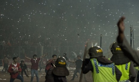   Suporter Persija Jakarta (Jakmania) melempari petugas kepolisian saat pertandingan Persija melawan Sriwijaya FC pada ajang Torabika Soccer Championship di Stadion Utama Gelora Bung Karno, Jakarta, Jumat (24/6).