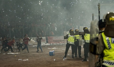 Suporter Persija Jakarta (Jakmania) melempari petugas kepolisian saat pertandingan Persija melawan Sriwijaya FC pada ajang Torabika Soccer Championship di Stadion Utama Gelora Bung Karno, Jakarta, Jumat (24/6).