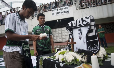 Suporter PSS Sleman meletakkan bunga di depan foto korban bentrok antar suporter saat laga Indonesia Soccer Championship (ISC) B 2016 di Stadion Maguwoharjo, Sleman, DI Yogyakarta, Senin (23/5). 