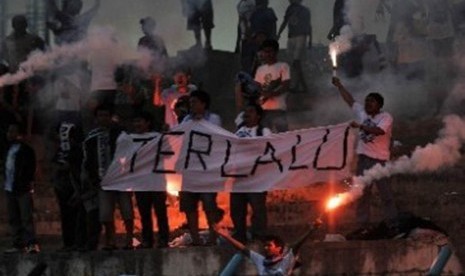 Suporter salah satu kesebelasan membentangkan spanduk dan menyalakan kembang api dalam laga lanjutan Liga Primer Indonesia antara Tangerang Wolves lawan Jakarta FC di Stadion Benteng, Tangerang, Banten. 