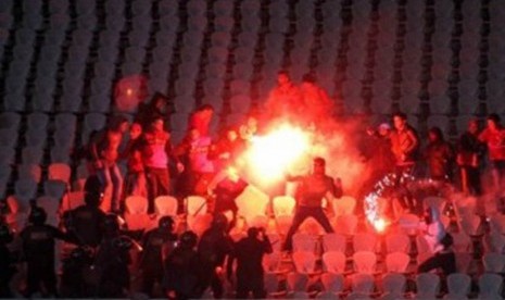 Suporter sepakbola Mesir terlibat bentrok dengan aparat kepolisian saat kerusuhan pecah dalam laga Al-Ahly lawan Al-Masry di Port Said, Mesir, awal Februari lalu. 