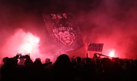 Suporter tim sepak bola Arema atau Aremania menyalakan lampu suar atau flare saat perayaan Hari Ulang Tahun (HUT) Ke-35 Arema di kawasan Bundaran Tugu, Kota Malang, Kamis (11/8/2022) dini hari. Perayaan HUT Arema dengan tema Jiwa Jawara tersebut diisi dengan malam refleksi dan pesta api suar. 