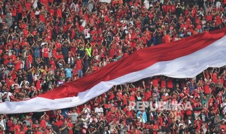 Suporter Timnas Indonesia U-22 memberikan dukungan dalam laga persahabatan melawan Myanmar di Stadion Pakansari, Cibinong, Bogor, Selasa (21/3).