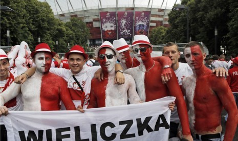 Suporter timnas Polandia menghiasi tubuh mereka dengan warna bendera nasional saat akan menyaksikan pertandingan Polandia lawan Yunani di laga Grup A Piala Eropa 2012 di Warsawa pada Jumat (8/6). 