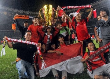 Suporter Indonesia tetap ceria usai final leg kedua Rabu malam. Mereka berfoto bersama replika Piala AFF.