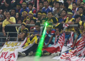 Suporter Malaysia menembakan sinar laser