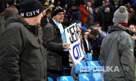 Supoter City membawa poster menprotes sanksi UEFA kepada City sebelum  laga Manchester City melawan West Ham United di Etihad Stadium, Kamis (20/2) dini hari.