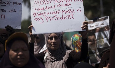 Supporters of Egypt's ousted President Mohammed Mursi hold banners denouncing the killing of Muslim Brotherhood supporters near Cairo University, Egypt, on July 8, 2013. (File photo)