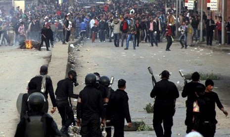 Supporters of the Muslim Brotherhood and ousted Egyptian President Mohamed Mursi run after riot police fired tear gas during clashes in Cairo December 20, 2013. 