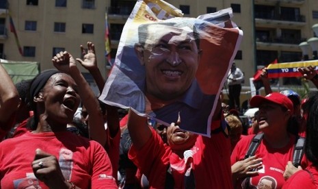 Supporters of Venezuela's President Hugo Chavez hold a picture of him as they attend a rally in Caracas March 3, 2013.