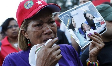 Supporters of Venezuela's President Hugo Chavez react to the announcement of his death outside the hospital where he was being treated, in Caracas, March 5, 2013. 