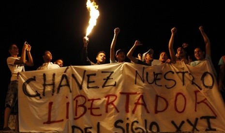 Supporters of Venezuela's President Hugo Chavez react to the announcement of his death outside the hospital where he was being treated, in Caracas, March 5, 2013.