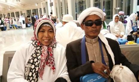 Supratman (kanan), seorang jamaah difabel netra yang berangkat didampingi Minarsik (kiri) saat menunggu kepulangan ke Tanah Air di Bandara Amir Muhammad bin Abdulaziz Madinah, Senin (9/9). Supratman bersyukur, ia bisa menjalankan ibadah haji dengan lancar tahun ini.