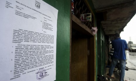 Surat pemberitahuan dari Pemprov DKI Jakarta tertempel di salah satu rumah di kawasan Kalijodo, Jakarta, Minggu (14/2).