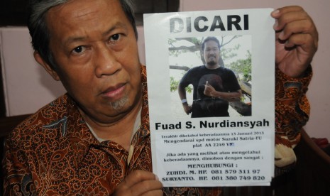 Suryanto menunjukkan poster bergambar putranya Fuad Sigit Nurdiansyah, mahasiswa UGM yang hilang tiga bulan, Senin (29/4).