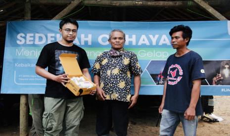 Sustainability Senior Manager ALAMI Group, Risyad Setiaputra menyerahkan paket lampu limar kepada tokoh masyarakat Dusun Cilele, Oman, didampingi warga setempat di Dusun Cilele, dusun di wilayah Karawang yang belum terpapar aliran listrik.