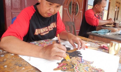 Sutarmi sedang memulas wayang kulit tokoh Rajamala di Sanggar Aruming Budoyo, Dukuh Butuh, Desa Sidowarno, Kabupaten Klaten, Jawa Tengah, Rabu (25/12).