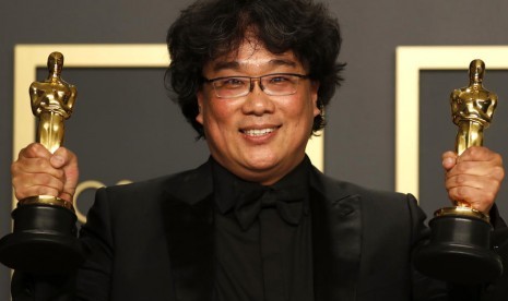 Sutradara film Parasite Bong Joon-ho berpose dengan Piala Oscar sebagai Best Directing dan Best International Feature. 