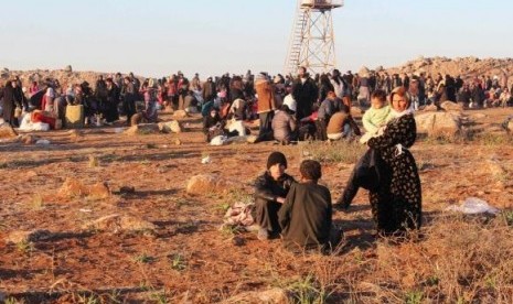 Syrian refugees, fleeing the violence in Syria, wait to enter Turkey on the Syrian-Turkish border in Shamm Alqrain village, northern countryside of Aleppo February 5, 2014.