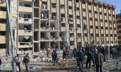 Syrian security personnel and civilians gather at the site where two explosions rocked the University of Aleppo in Syria's second largest city, January 15, 2013.  