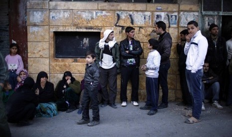 Syrians wait outside a bakery in Aleppo city December 27, 2012. Syria's 21-month-old conflict has killed 44,000 people.   