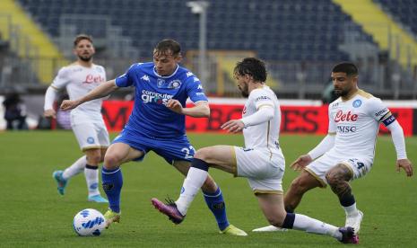 Szymon Zurkowski dari Empoli, kiri, menantang Mario Rui dari Napoli selama pertandingan sepak bola Serie A antara Empoli dan Napoli di Stadion Castellani, Empoli, Italia, Ahad, 24 April 2022.