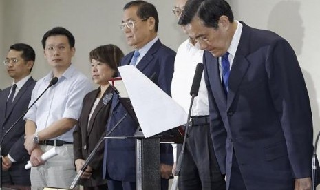 Taiwan President Ma Ying-jeou (R) bows during a news conference with party officials after the ruling Kuomintang (KMT) party was defeated in the local elections in Taipei November 29, 2014. 