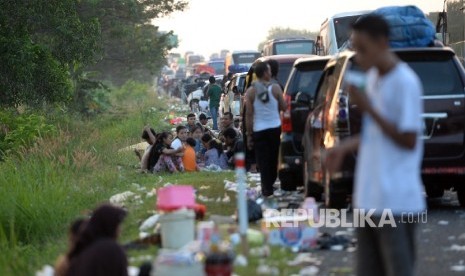 Tak Kunjung Lancar di Pejagan. Pedagang dadakan menawarkan dagangan kepada pemudik terjebak macet parah di Tol Pejagan, Jawa Tengah, Senin (4/7). Memasuki H-2 lebaran idul fitri macet parah masih terjadi di ruas Tol Pejagan bahkan sempat mencapai 39 km. Ma