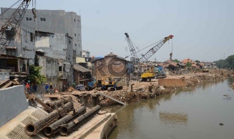 Tampak alat berat crane sedang beroperasi melakukan pemasangan tiang pancang dekat sisa-sisa bangunan rumah yang tergusur normalisasi Sungai Ciliwung di Kampung Pulo, Jatinegara, Selasa (25/8).  (Republika/Yasin Habibi)