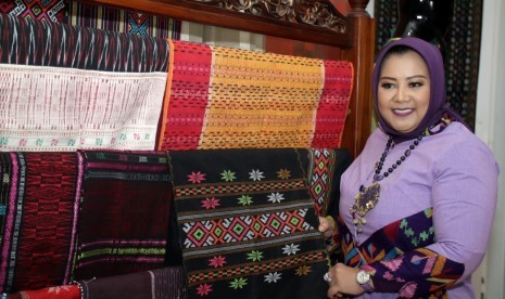 Tampak Anna Mariana, Ketua Umum dan Penanggung Jawab Acara PPTSI 2019  berpose bersama kain tenun dan songket nasional