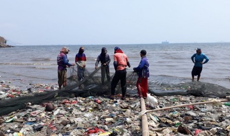 Tampak nelayan di wilayah Sukaraja, Bandar Lampung sedang berada diatas tumpukan sampah di tepi pantai