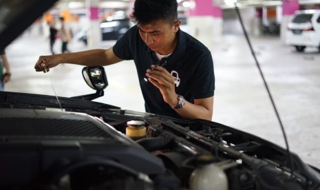 Tampak seorang petugas Carsome sedang memeriksa kondisi kendaraan bekas yang akan dijual pemiliknya.