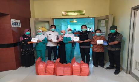 Tampak tim ACT dan UM bersama tenaga medis saat menyerahkan bantuan makanan