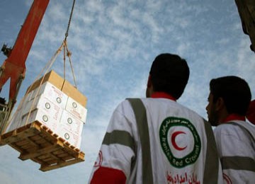 Tampak anggota Iranian Red Crescent tengah mengawasi bantuan yang dibawa ke kapal.