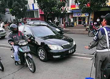 Tampak seorang petugas melarang kendaraan pribadi melintasi jalur busway khusus untuk bus transjakarta.