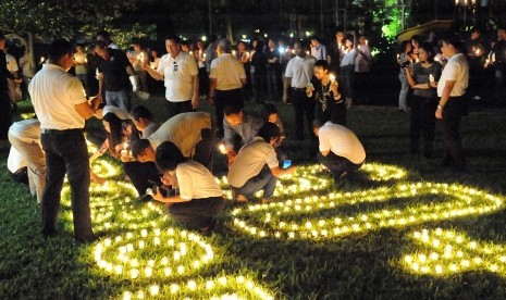 Tamu dan karyawan menyalakan lilin dalam ajang Earth Hour di Hotel Borobudur Jakarta.