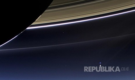 Tanda panah menunjukkan posisi planet bumi dan bulan diambil oleh wahana angkasa Cassini yang mengorbit di sekitar planet tersebut. 