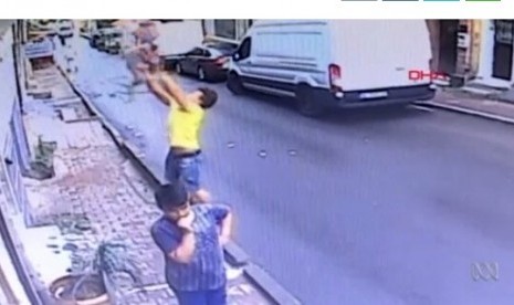 Tangkapan layar CCTV pemuda yang menangkap anak balita terjatuh dari apartemen.