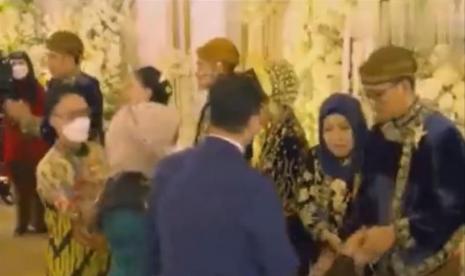 Tangkapan layar video Sofiatun Gudono memberi kode ingin berfoto bersama Anies Rasyid Baswedan bersama istri, namun akhirnya urung karena petugas meminta Anies langsung meninggalkan lokasi karena masih banyak tamu.