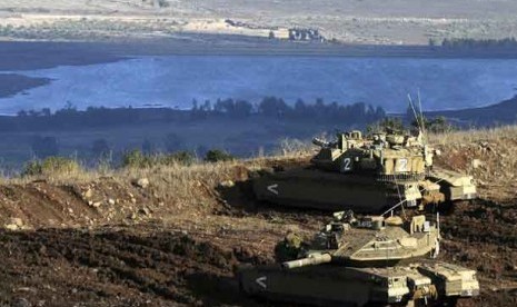 Tank-tank Israel dalam posisi menghadap sebuah desa Suriah dari Dataran Tinggi Golan yang dicaplok Israel, Senin (12/11).