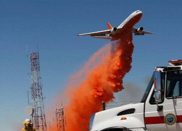 Tanker udara, pesawat jumbo jet DC-10 mengeluarkan bom air dengan campuran bahan tahan api di Palmdale, California.