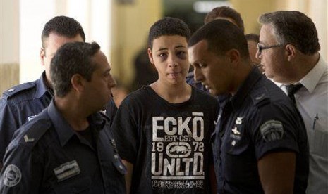 Tariq Abu Khdeir (15 years), Mohammed Abu Khdeir's cousin, is escorted by Israeli prison guards during an appearance at Jerusalem magistrate's court Sunday, July 6, 2014.