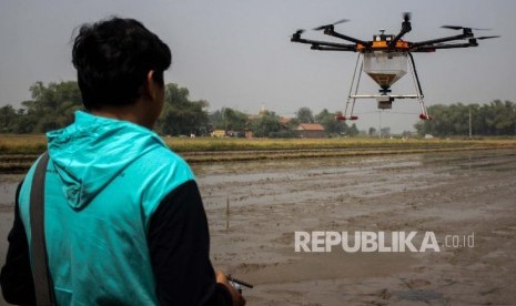 Teknisi melakukan uji coba penggunaan wahana tak berawak atau drone untuk menebar benih padi di Persawahan kawasan Krian, Sidoarjo, Jawa Timur, Sabtu (29/6/2019). Drone untuk menebar benih padi di atas sawah tersebut untuk membantu mengurangi beban para petani dan meningkatkan efisiensi pertanian. 