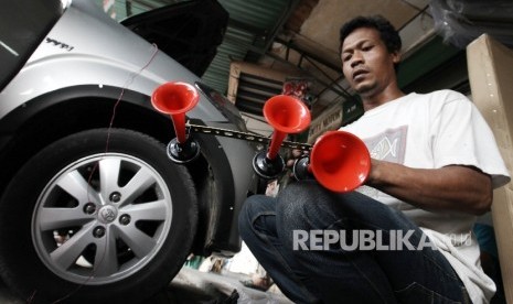 Teknisi memasang klakson jenis Terompet atau yang lebih dikenal sebagai klakson Telolet di gerai Duta Motor, Pasar Mobil Kemayoran, jakarta, Ahad (25/12).