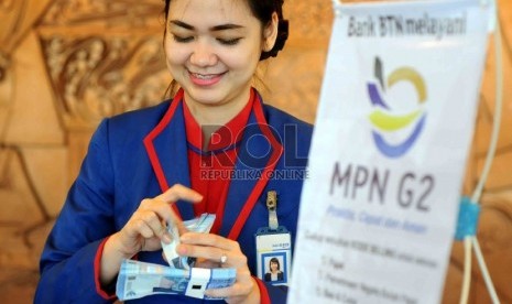 Teller Bank Tabungan Negara (BTN) menghitung uang rupiah di Banking Hall Bank BTN, Jakarta, Kamis (9/7).