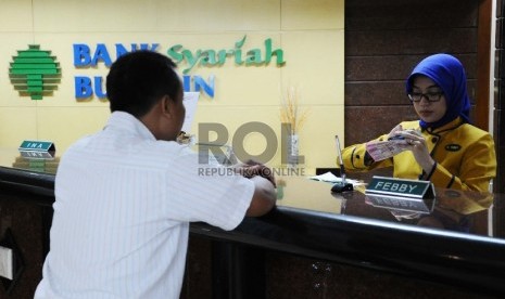  Teller melakukan aktifitas di kantor Bank Syariah Bukopin, Jakarta, Selasa (6/10). 