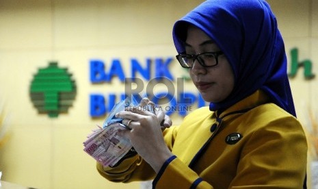  Teller melakukan aktifitas di kantor Bank Syariah Bukopin, Jakarta, Selasa (6/10).