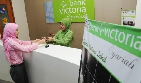 Teller melayani nasabah di Bank Victoria Syariah, Senayan, Jakarta.