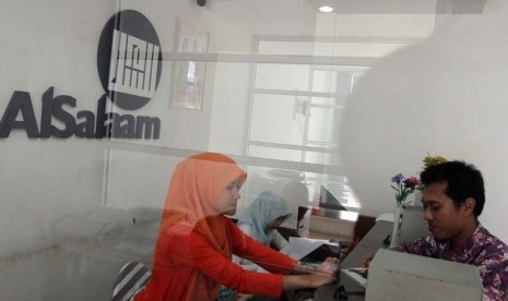 Teller melayani nasabah di banking hall salah satu kantor cabang BPRS Al Salaam, Jakarta, Jumat (13/6).